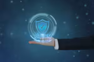 Businessman's hand holding a virtual glowing security shield with a check mark symbol, representing SSL data protection.