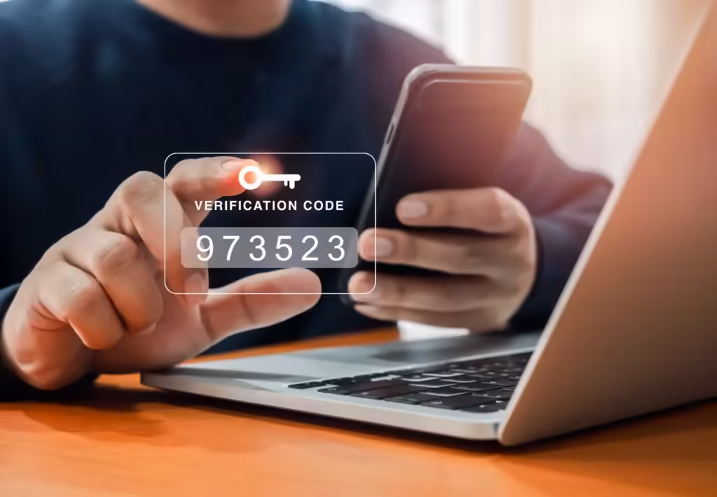 Une personne tenant un smartphone et touchant un écran virtuel affichant un code de vérification et une icône de clé, symbolisant l'authentification à deux facteurs.