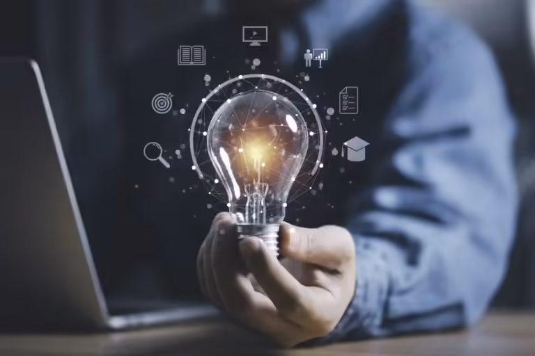 Une main d'homme tenant une ampoule allumée, entourée d'icônes représentant la connaissance, la stratégie et le réseautage, symbolisant la pensée et les idées novatrices.